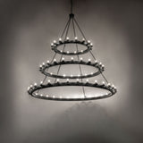 Dark room-lit view of the Loxley three-tier chandelier illuminating the surrounding space.
