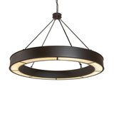 Lit view of circular chandelier with beige art glass diffuser and bronze finish.