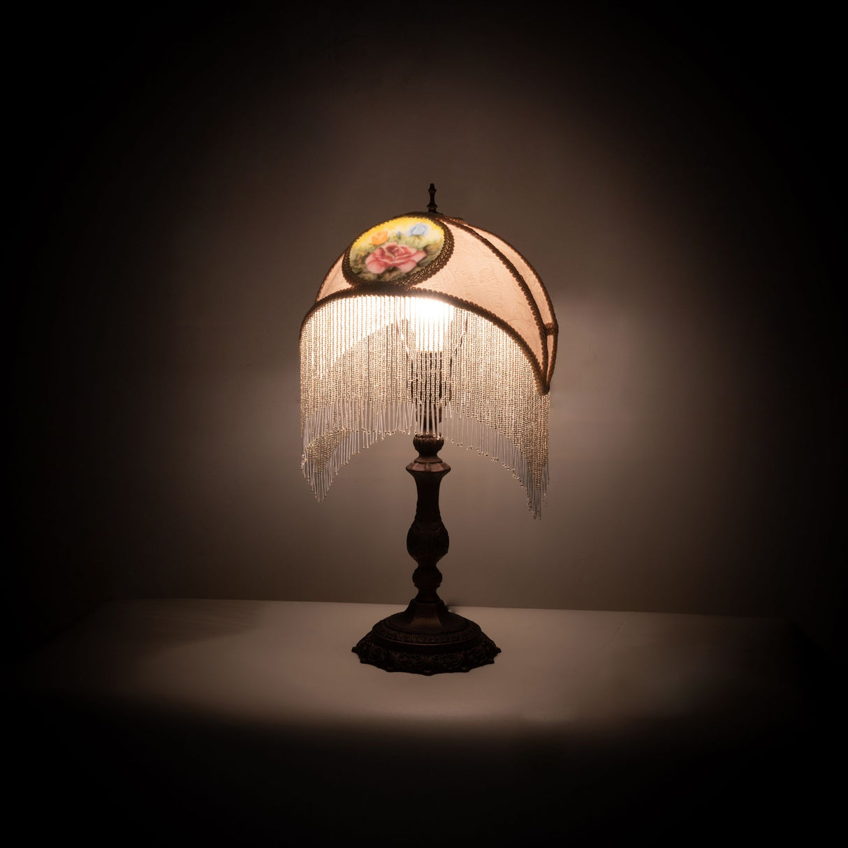 Accent lamp illuminated with ivory shade and reverse-painted rose medallion design.