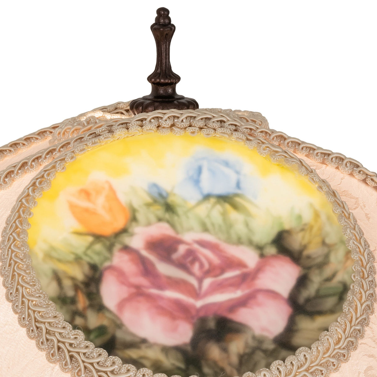 Detailed view of reverse-painted rose medallion on ivory fabric lamp shade.