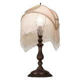 Side view of ivory damask shade lamp with bronze base and fringe detail.