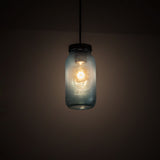 Glowing blue Mason jar pendant in a dark room.