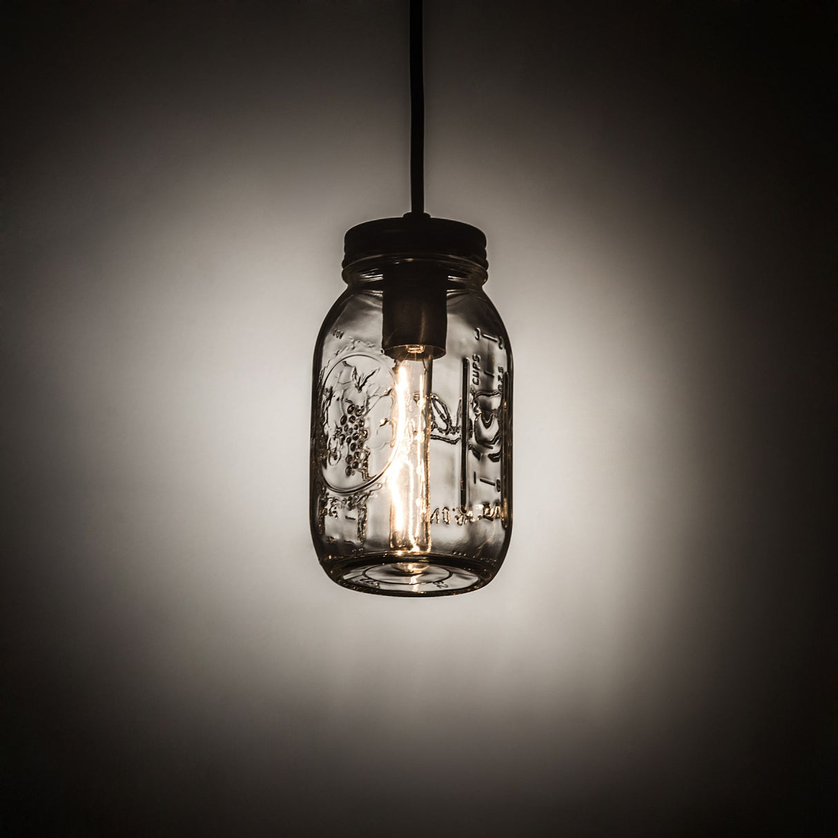 Illuminated mason jar mini pendant casting a warm glow.