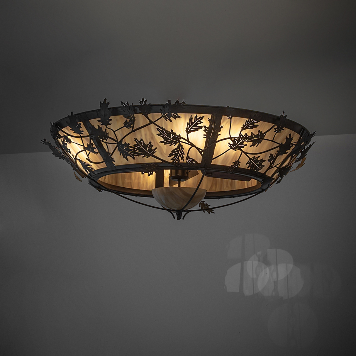 Dim ambient shot of Oak Branch chandelier casting soft ceiling glow.