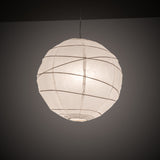 Illuminated paper lantern pendant in a dark room.