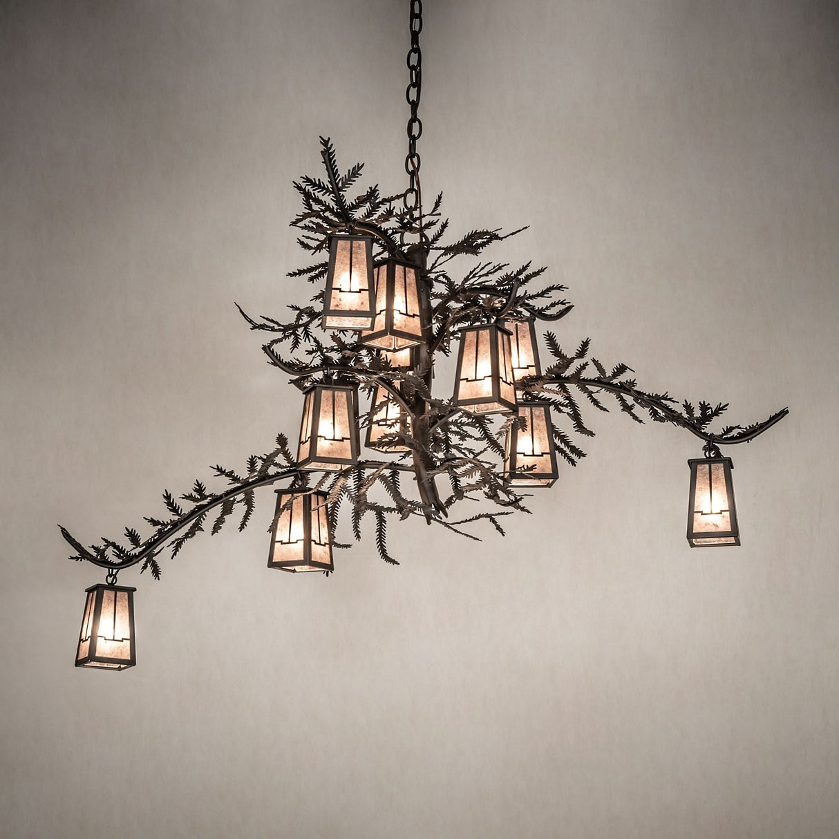 Pine branch chandelier casting warm ambient light in an interior setting.