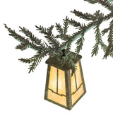 Close-up of Craftsman style lantern mounted on green pine branch arm.