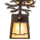 Close view of stained glass lantern shade and pine branch metalwork details.