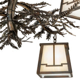 Lantern close-up showing beige iridescent art glass and metal pine branch accents.