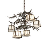 Lit view of 5 light chandelier glowing with beige art glass lanterns.