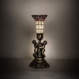 Cherub lamp illuminated in a soft ambient setting.