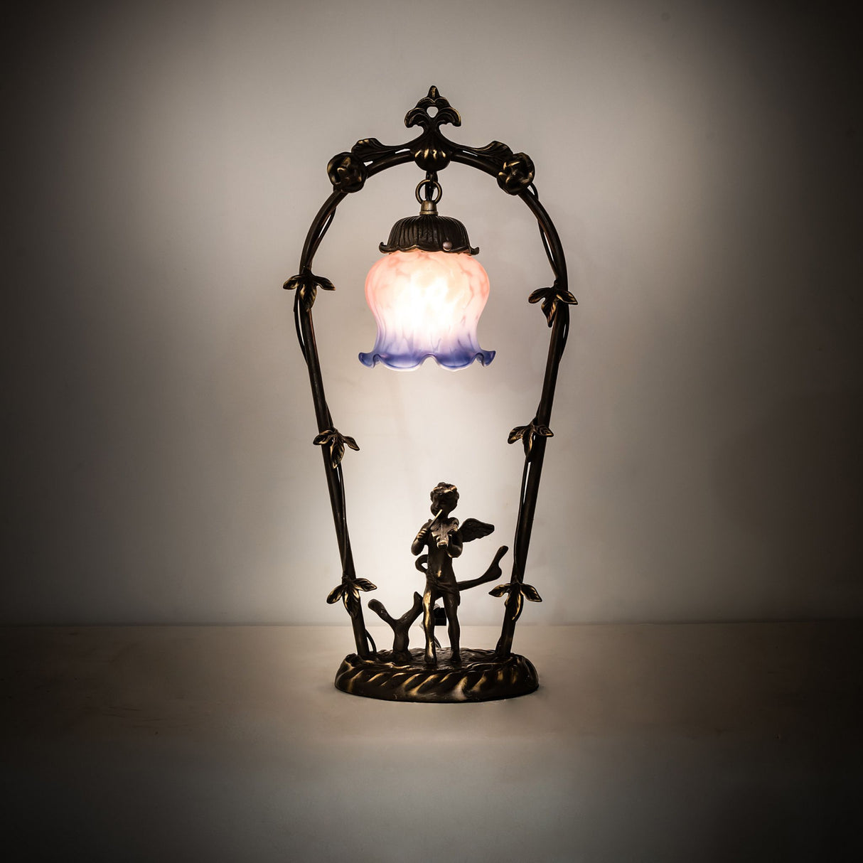 Illuminated view of Cherub With Violin Mini Lamp with pink and blue shade.