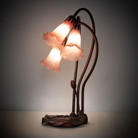illuminated amber view of pink tiffany pond lily accent lamp with glowing petal pink shades.
