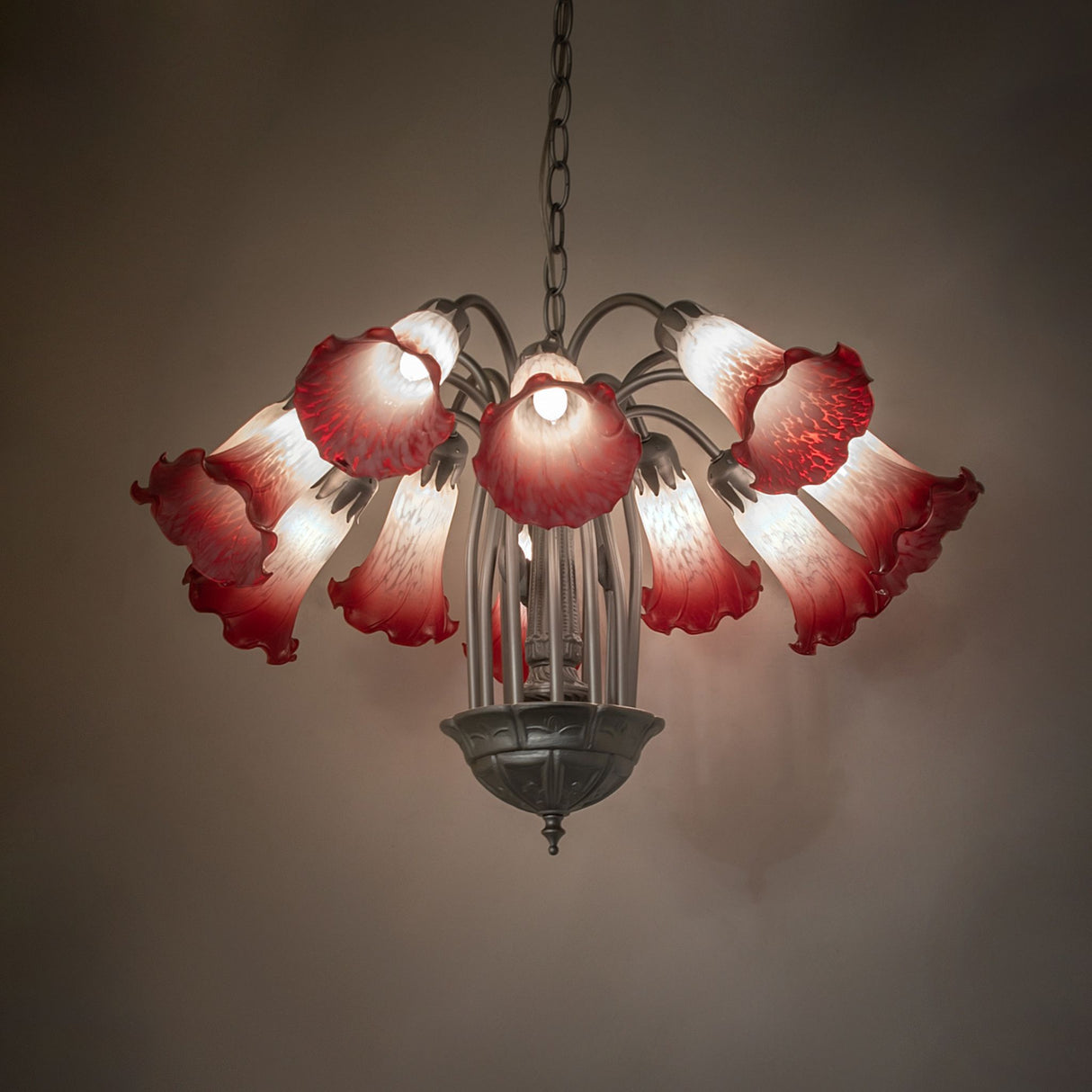 Ambient lighting view of chandelier showing warm glow and glass color variation.