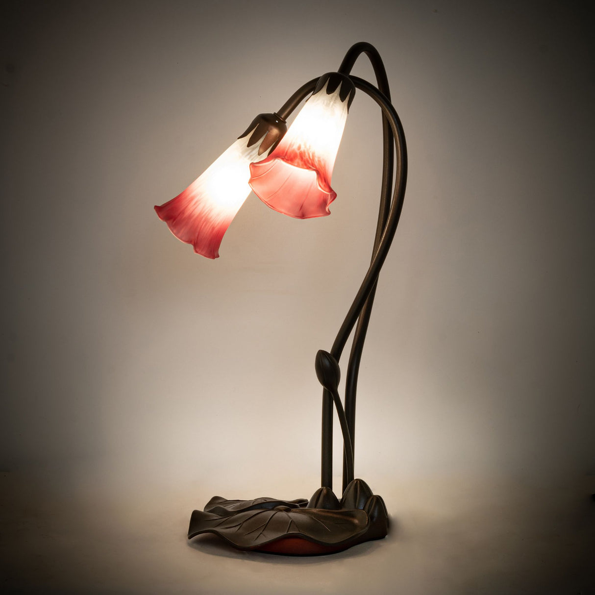 Illuminated view of the Pink/White Tiffany Pond Lily accent lamp glowing with soft hues.