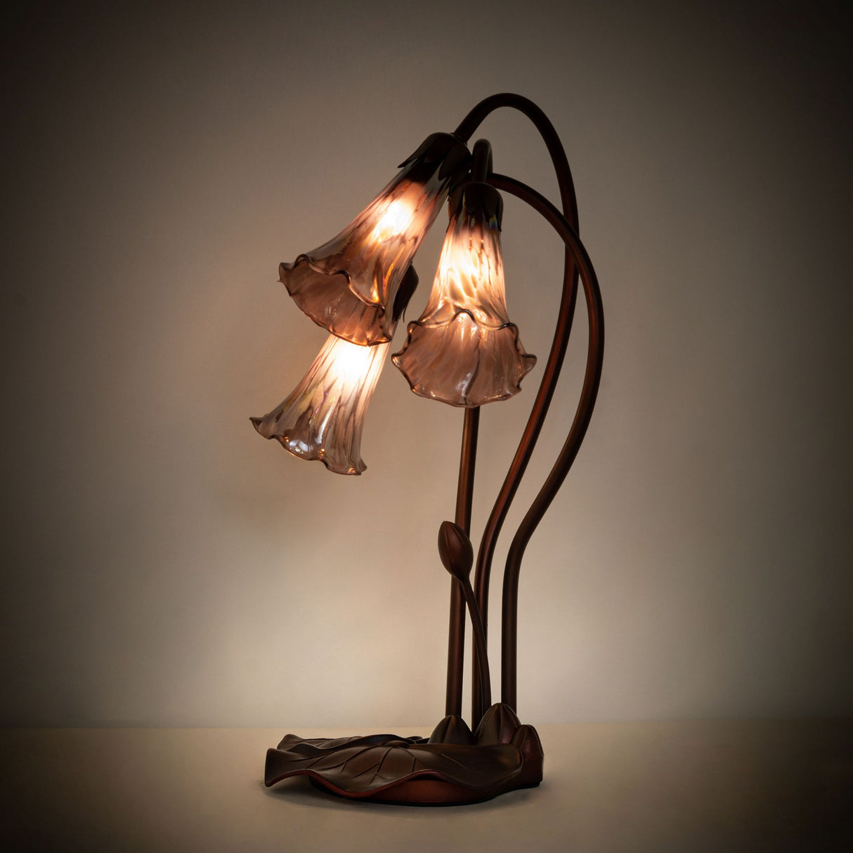 Illuminated purple iridescent Tiffany Pond Lily accent lamp showcasing its vibrant stained glass shades.