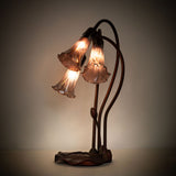 Illuminated purple iridescent Tiffany Pond Lily accent lamp showcasing its vibrant stained glass shades.