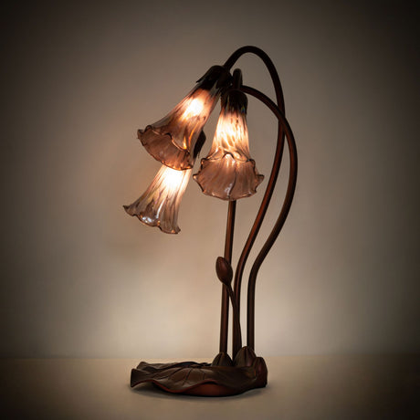 Illuminated purple iridescent Tiffany Pond Lily accent lamp showcasing its vibrant stained glass shades.