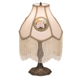 Full view of a 20" high reverse-painted roses table lamp with ivory fabric and fringe.
