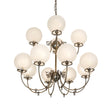 Lit view of gas and electric chandelier with frosted globe shades and antique brass finish.