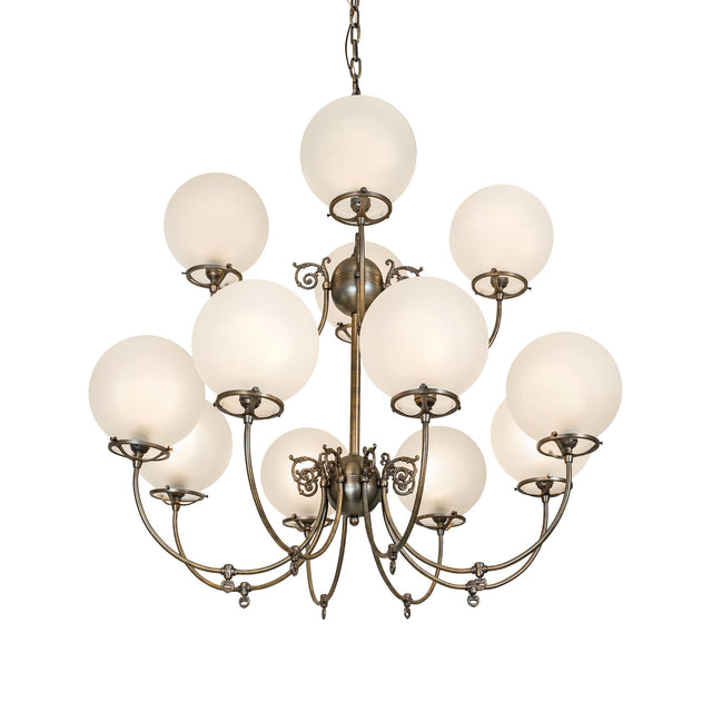 Lit view of gas and electric chandelier with frosted globe shades and antique brass finish.