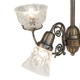 Detailed view of clear etched glass shade with wreath and garland motif.