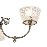 Close-up of antique brass arm joint and decorative hardware on chandelier.