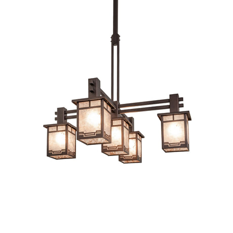 Roylance five light chandelier illuminated with warm glow and silver mica shades.