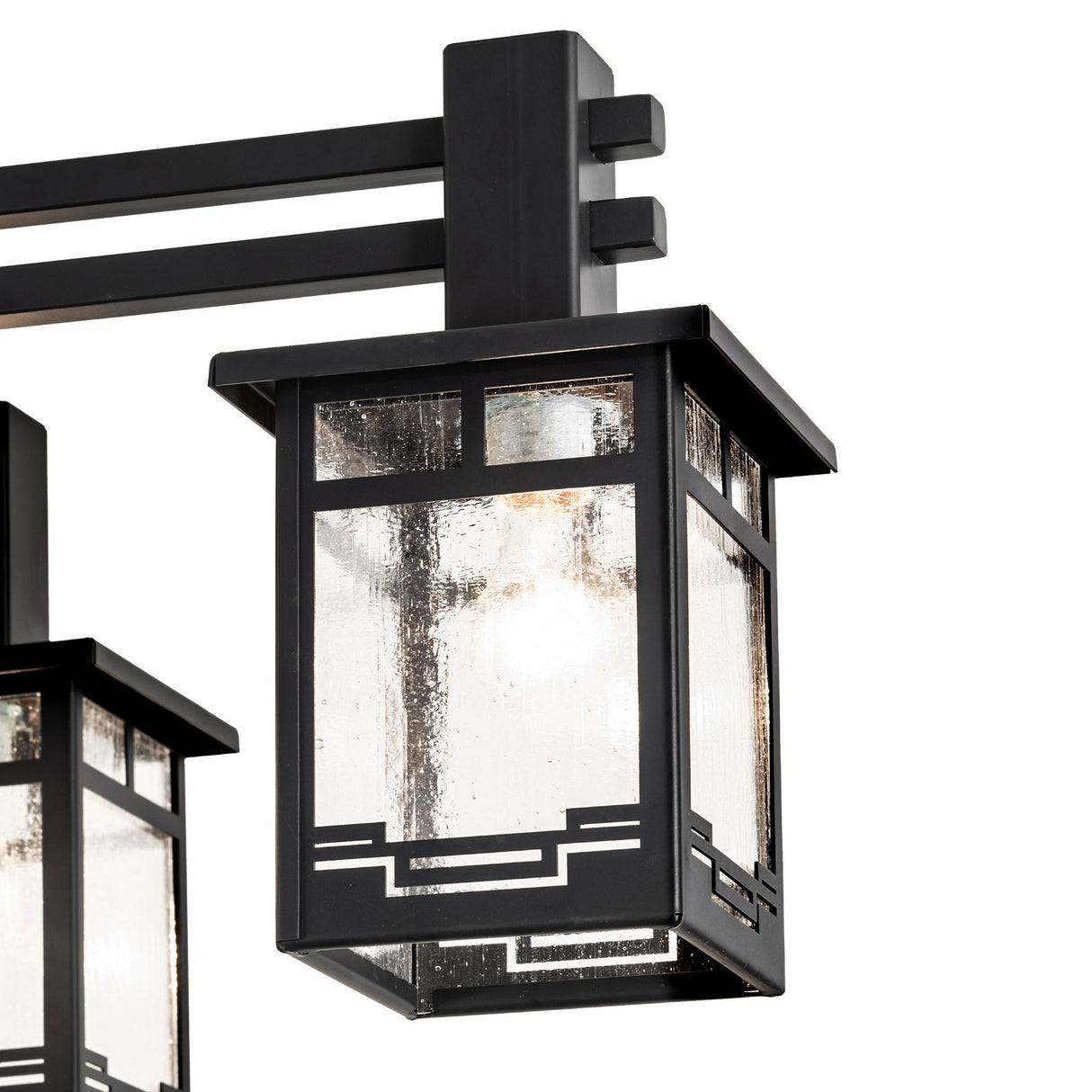 Closeup of Roylance chandelier clear seeded glass lantern with geometric trim.