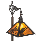 Close-up of amber mica shade with loon and pine cutout details lit.