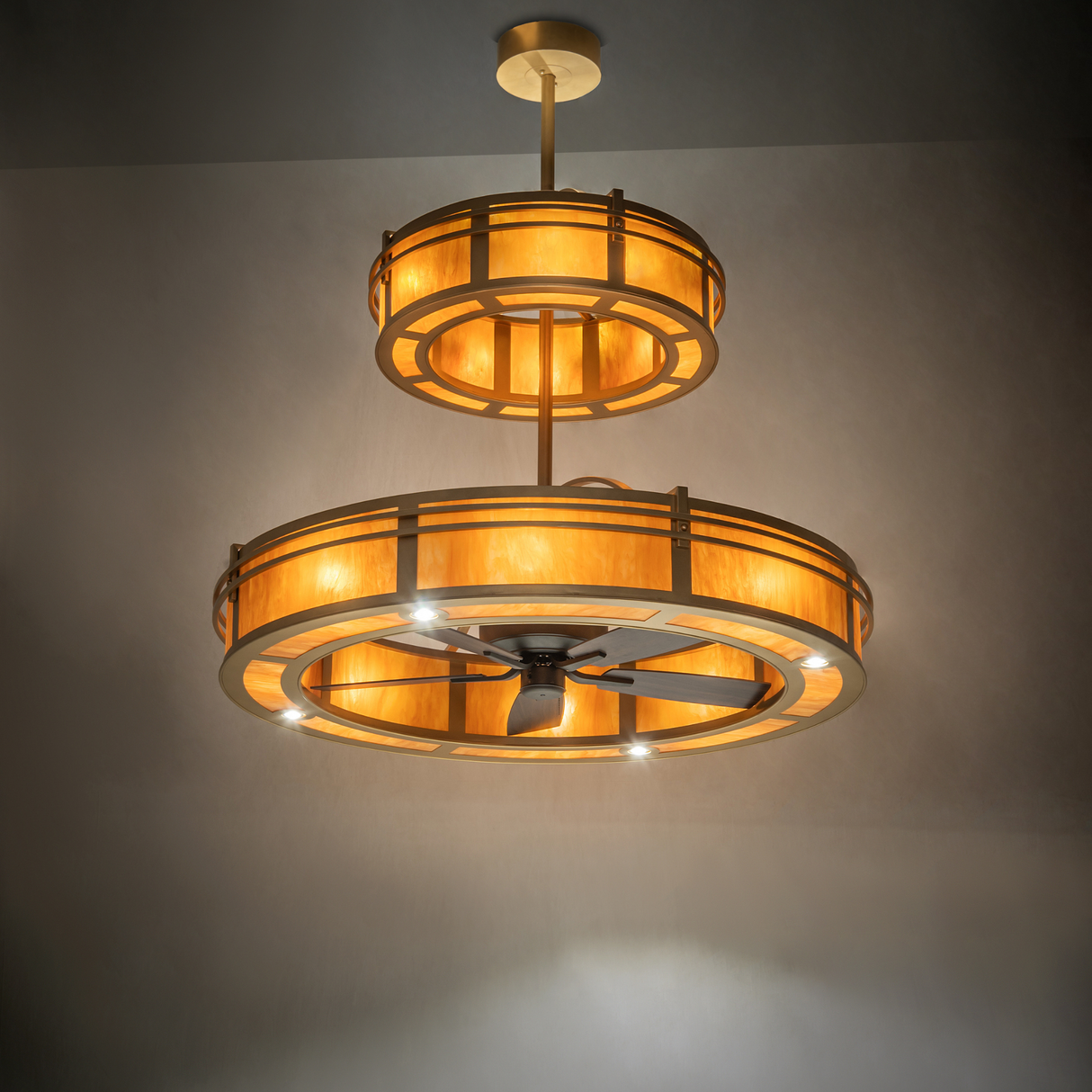 Warm ambient-lit view of Sargent chandelier fan glowing in golden tones.