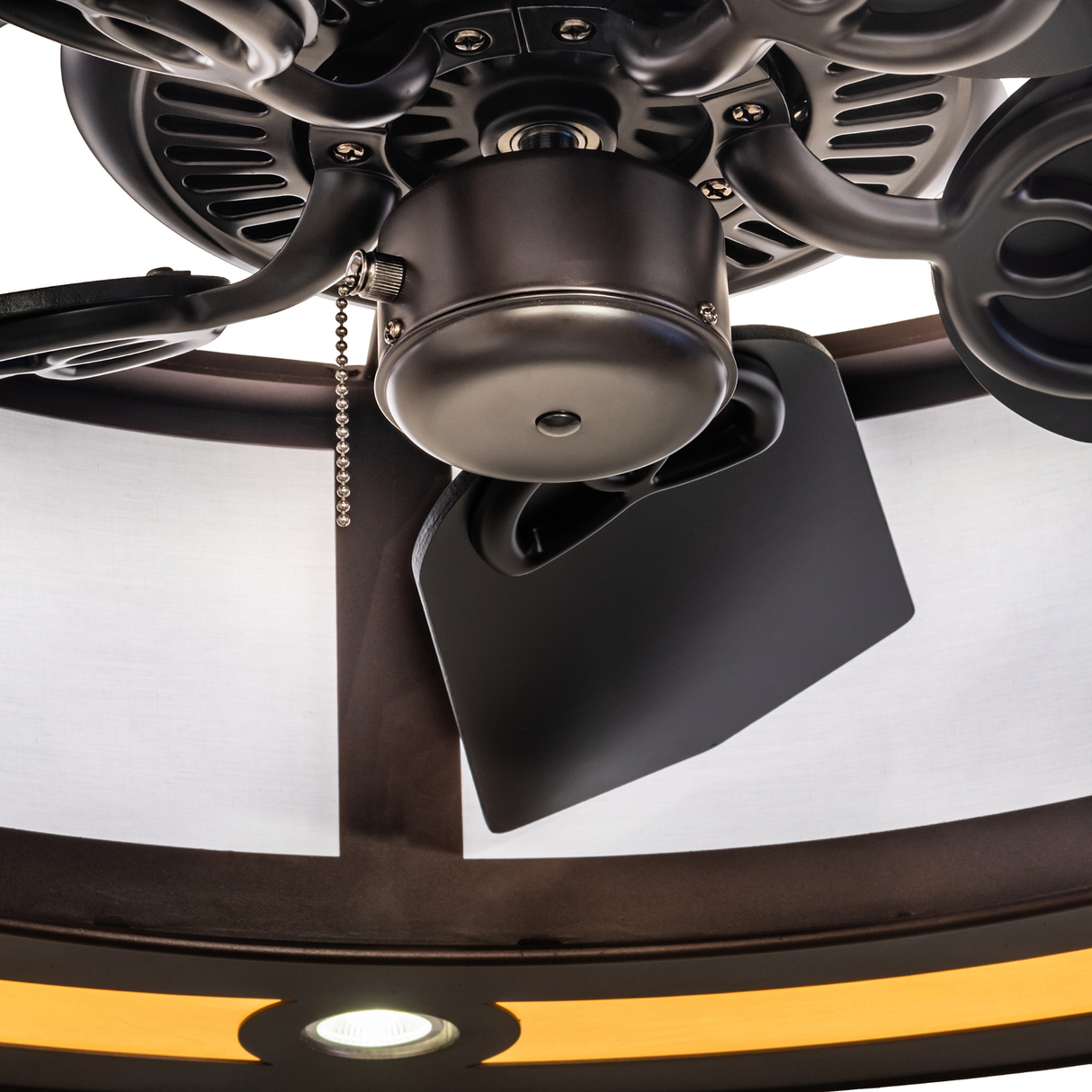 Close-up of fan motor and blades under illuminated diffuser.
