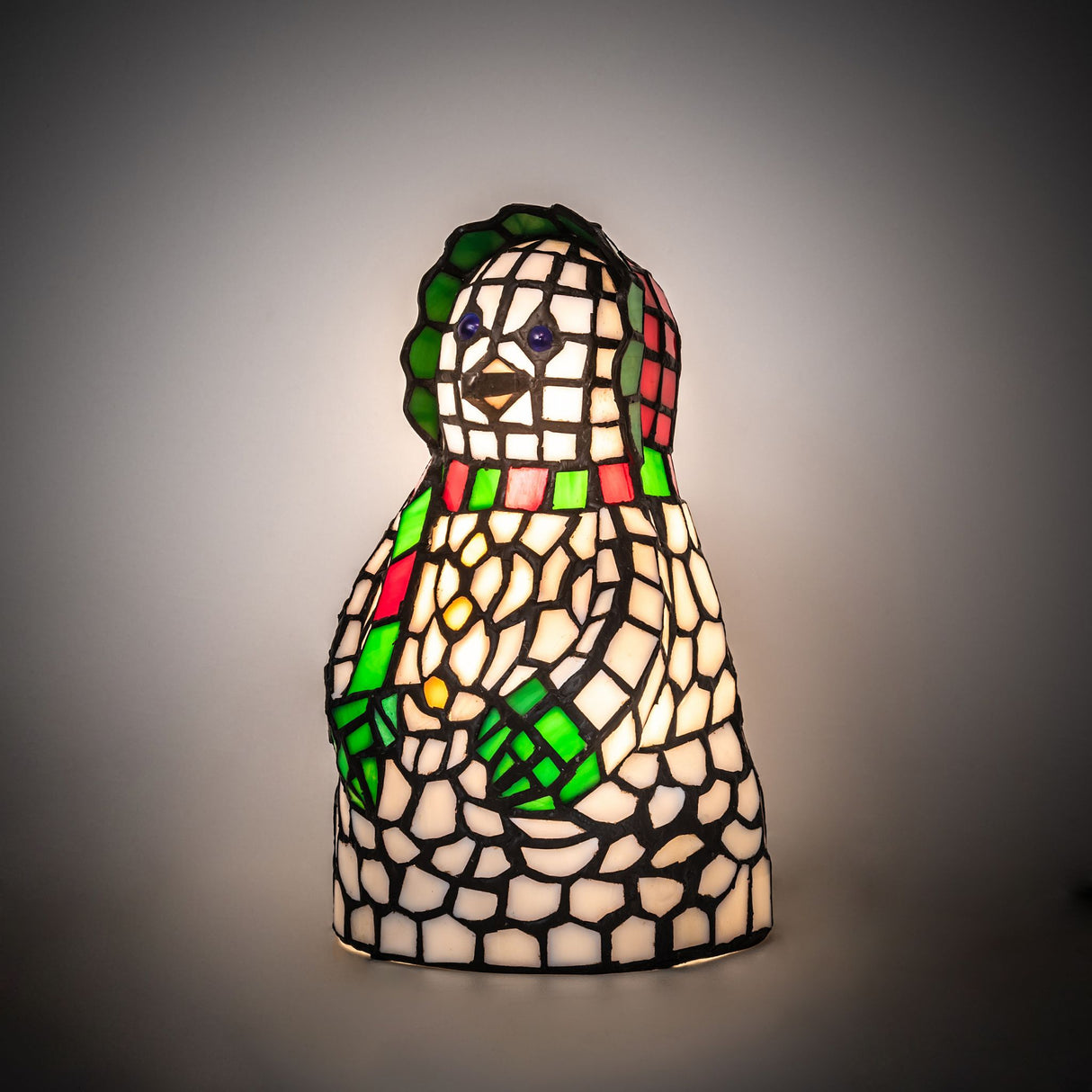 Snow woman accent lamp illuminated showing detailed mosaic design.