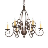Squire 6-light chandelier illuminated with candle bulbs, warm glow on gray wall.
