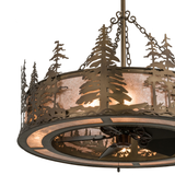 Closeup showing intricate pine tree metalwork and glowing mica shade.