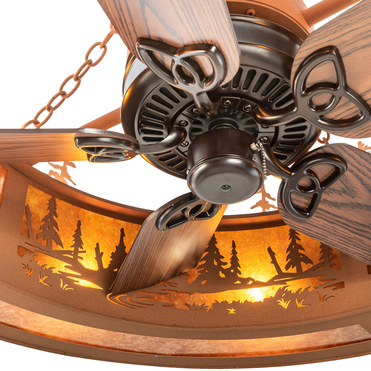 Close-up of fan blades and bronze housing beneath illuminated shade.