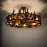 Dimly lit room view showing forest-themed chandelier fan in amber illumination.