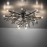 Thicket branch-inspired chandelier on ceiling, casting ambient light with sculptural metal branches.