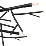 Detail view of candle-style bulb and socket on chandelier with branch-inspired metal arms.