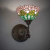 Wall-mounted Tiffany sconce illuminated, showcasing vibrant floral patterns.