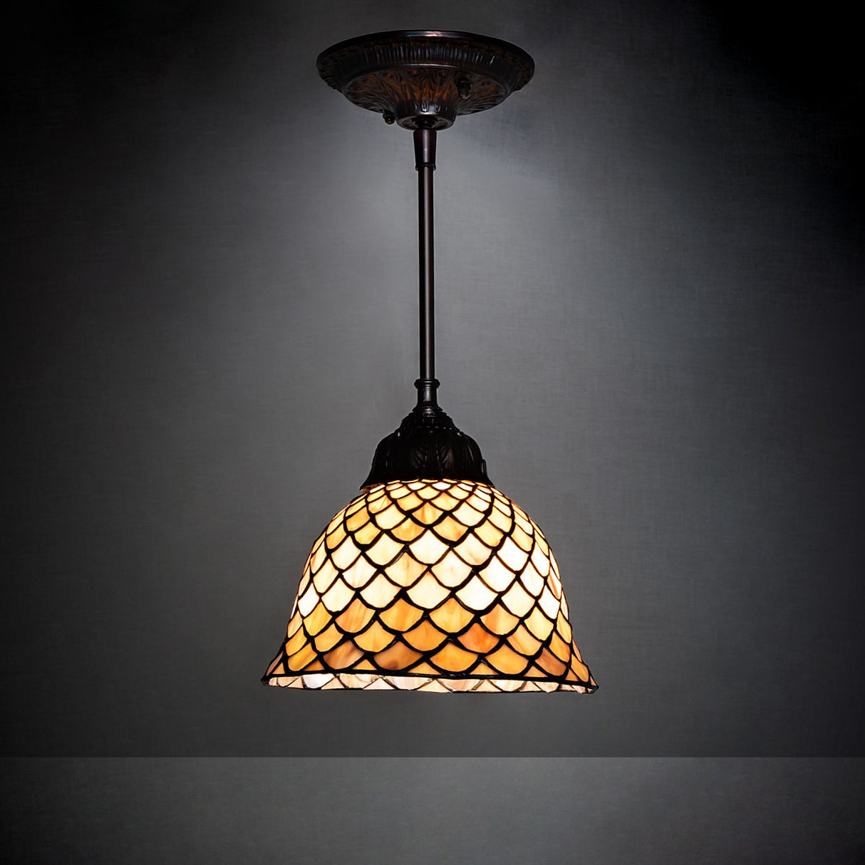Tiffany Fishscale Mini Pendant illuminated in a dim setting.