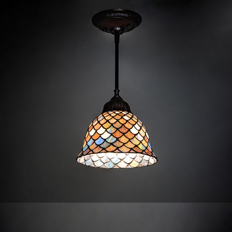 Illuminated Tiffany Fishscale mini pendant casting a warm glow in Mahogany Bronze.