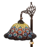 Close-up of lit peacock feather stained glass lamp shade.