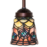 Close-up of intricate peacock feather design on stained glass shade.