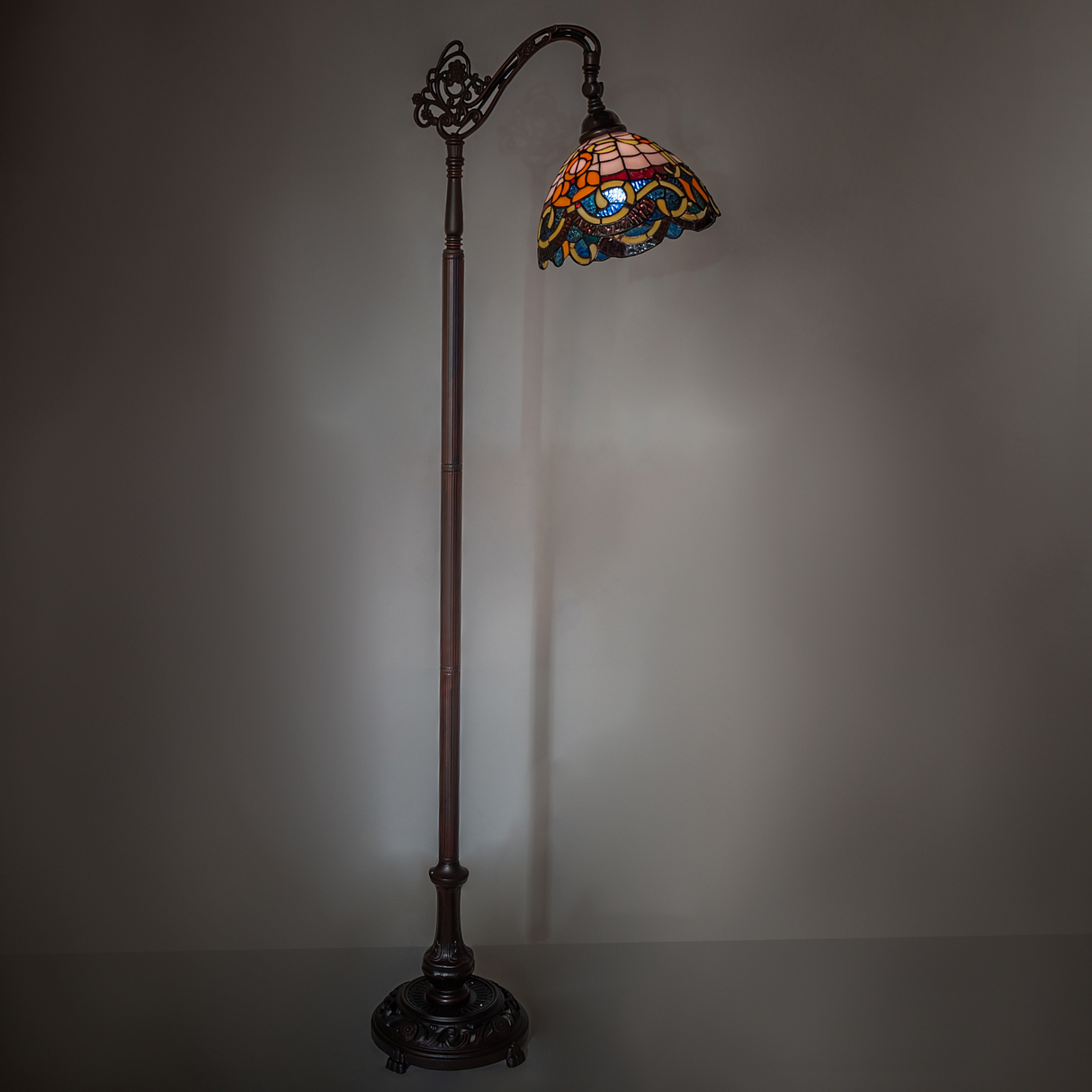 Tiffany floor lamp creating warm ambient lighting in room setting.