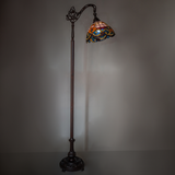 Tiffany floor lamp creating warm ambient lighting in room setting.