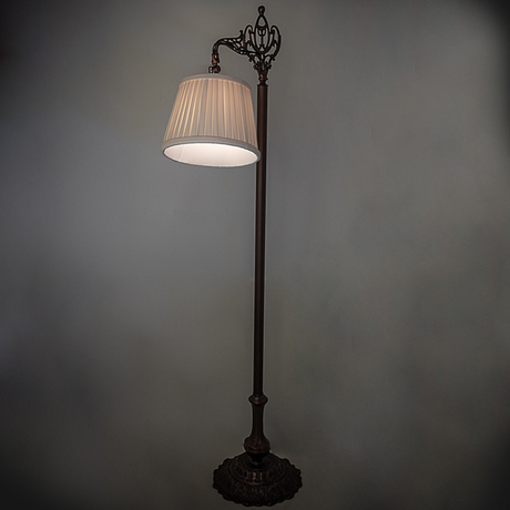 Victorian bridge arm lamp softly glowing in ambient lighting.