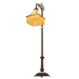 Angled lit view of Victorian glass shade with beaded fringe.