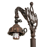 Close-up of ornate Victorian lamp arm and socket.