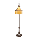 Front lit view of Victorian floor lamp with glowing amber glass.